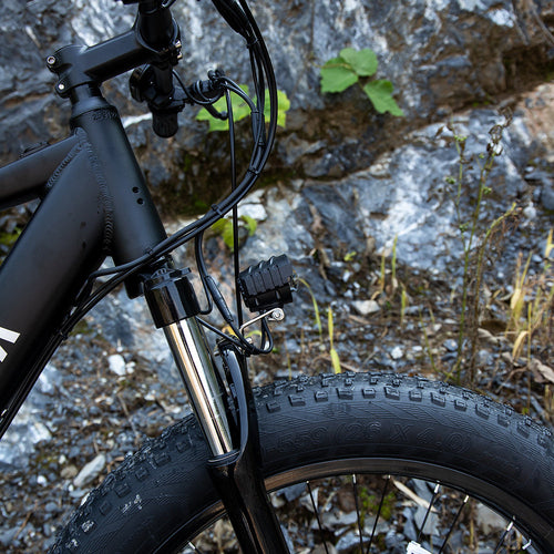 Close-up of SIVROCK V1 Shimano electric bike front fork and oversized tire, showcasing durable design and performance features.